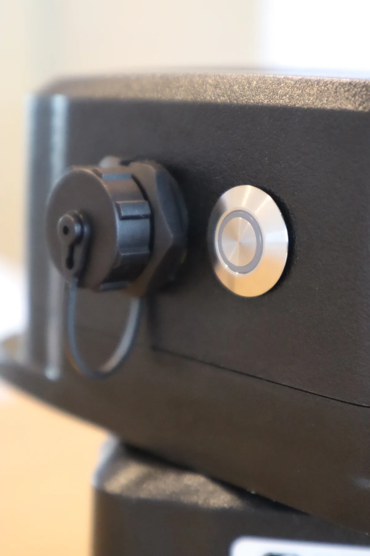 Close-up of the covered charging port and status button on the Vibe sensor