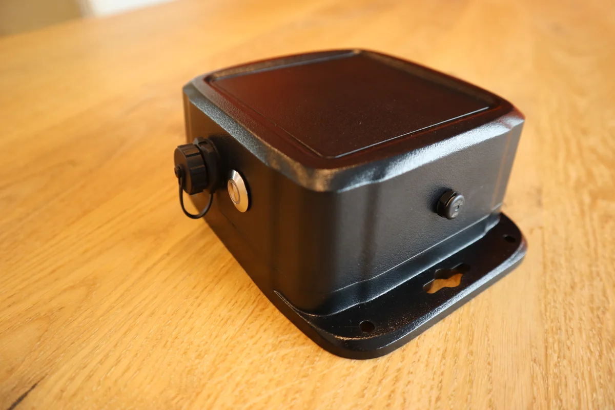 CAS Vibe vibration sensor with a black enclosure, mounting flange, status button and covered charging port