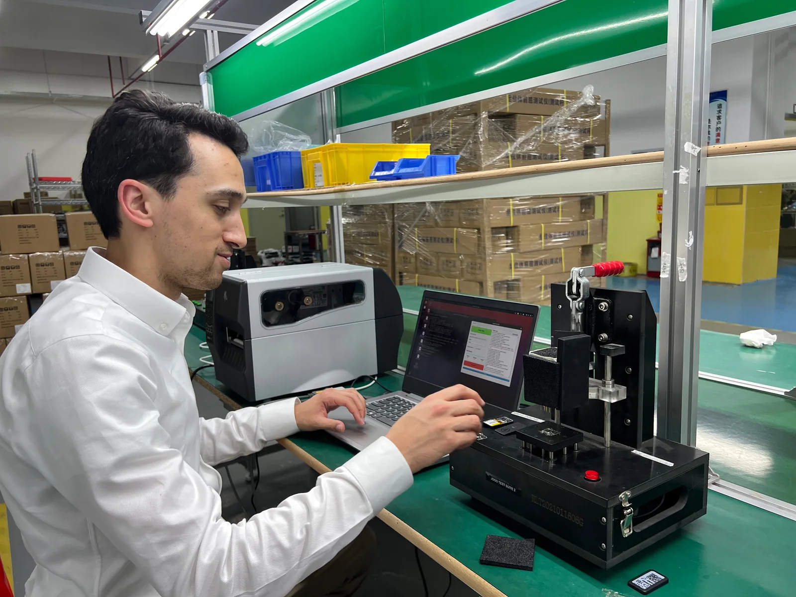 Insyght-engineer met productietestfixture en laptop aan een fabriekslijn