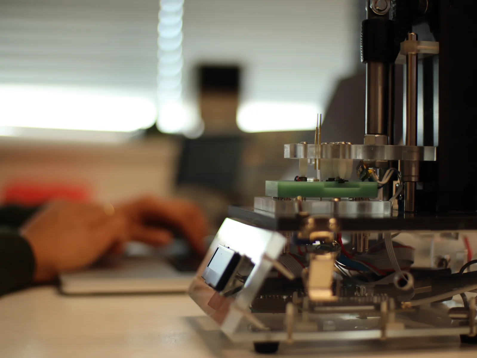 Insyght-testfixture met een ingeklemde printplaat en een engineer die ernaast werkt